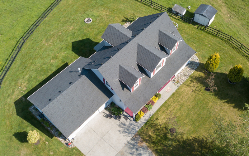 Drone view of single family house; roof replacement services; how long does a roof last; types of roofing materials