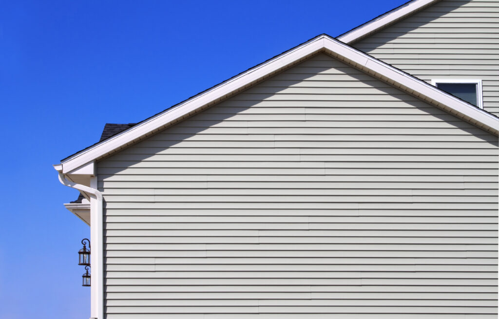 light colored vinyl siding on the side of a multistory home; vinyl siding replacement; vinyl siding installation; vinyl siding contractors