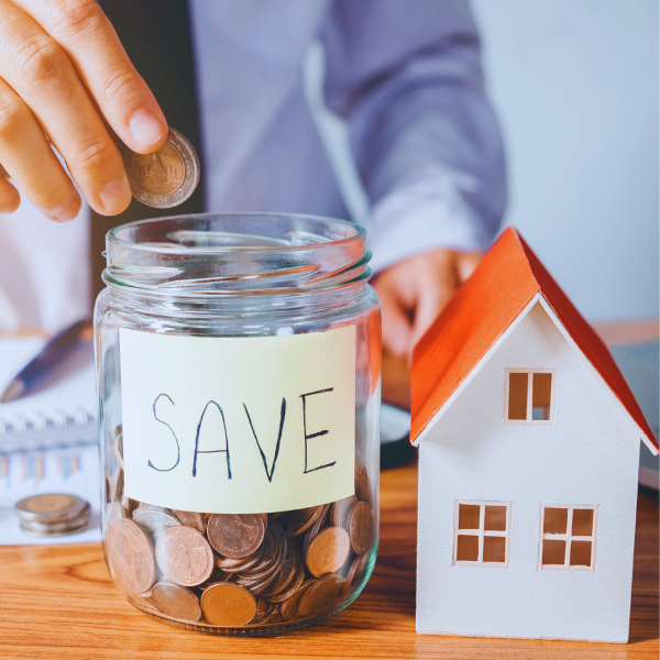 save money. "SAVE" written on jar with coins inside next to toy house