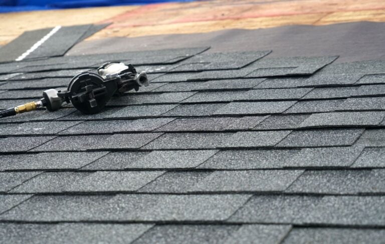 close-up of shingle roof with nail gun