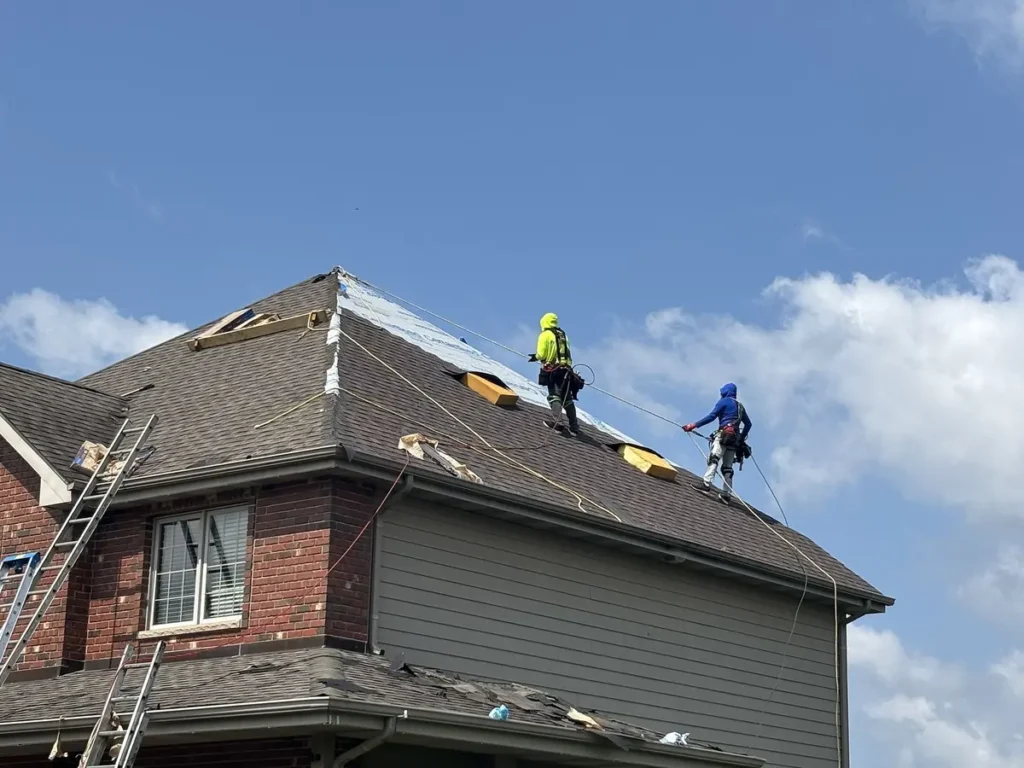 Discount Roof crew repairing a shingle roof after it sustained summer storm damage