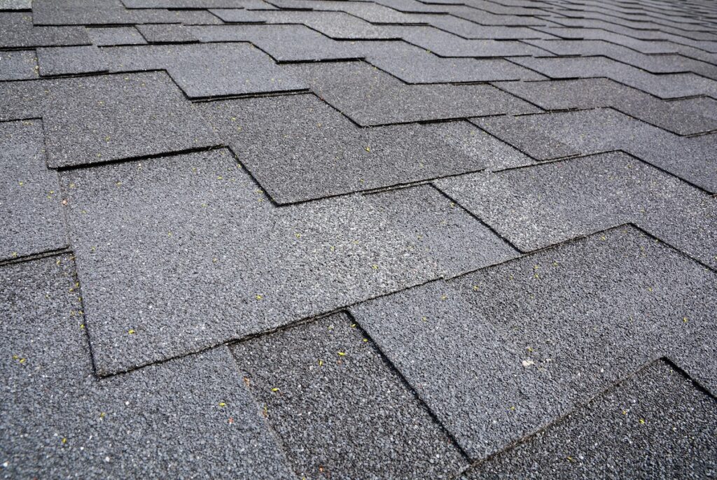 Close up view on Asphalt Roofing Shingles Background. Roof Shingles - Roofing.