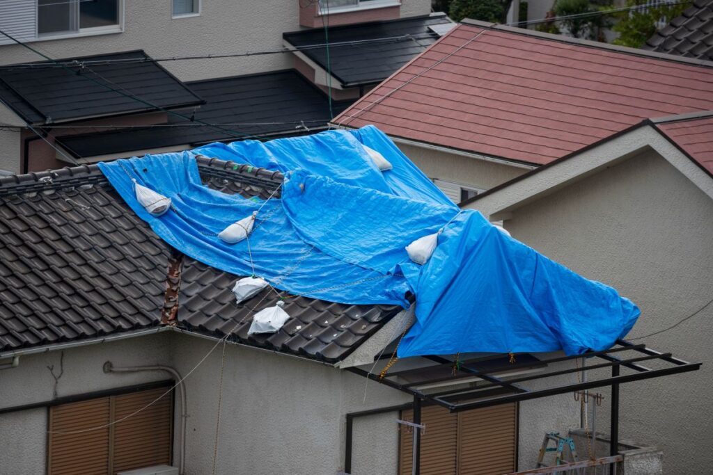 big tarp covering roof after storm damage