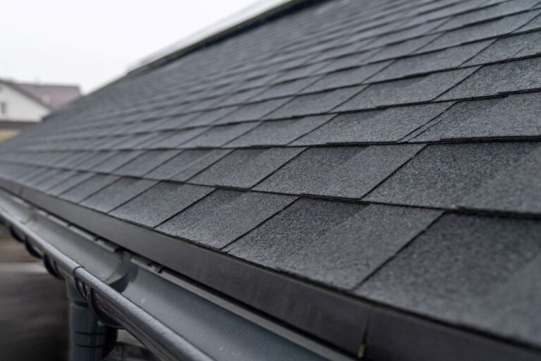 dark gray asphalt roof shingles with rain gutter system