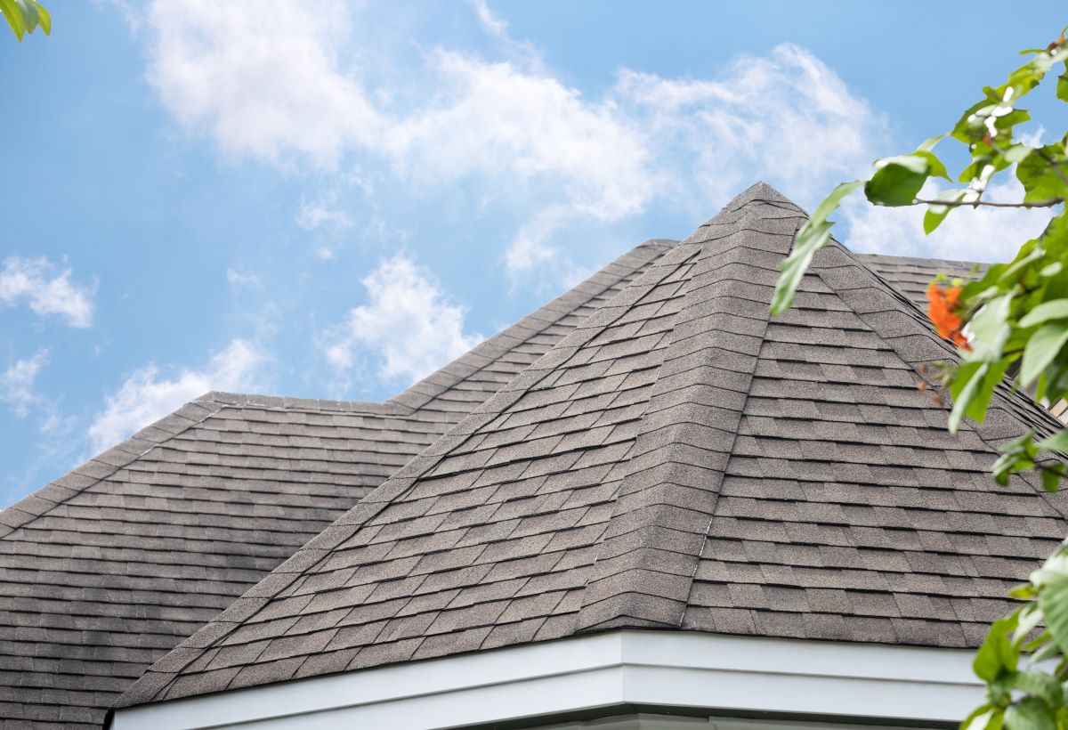 gray asphalt tile roof against blue sky