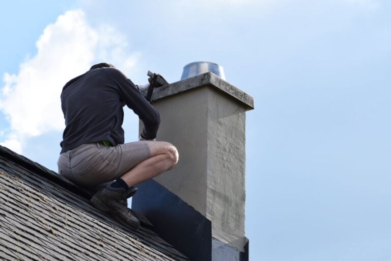 chimney flashing repair worker on the roof of a house