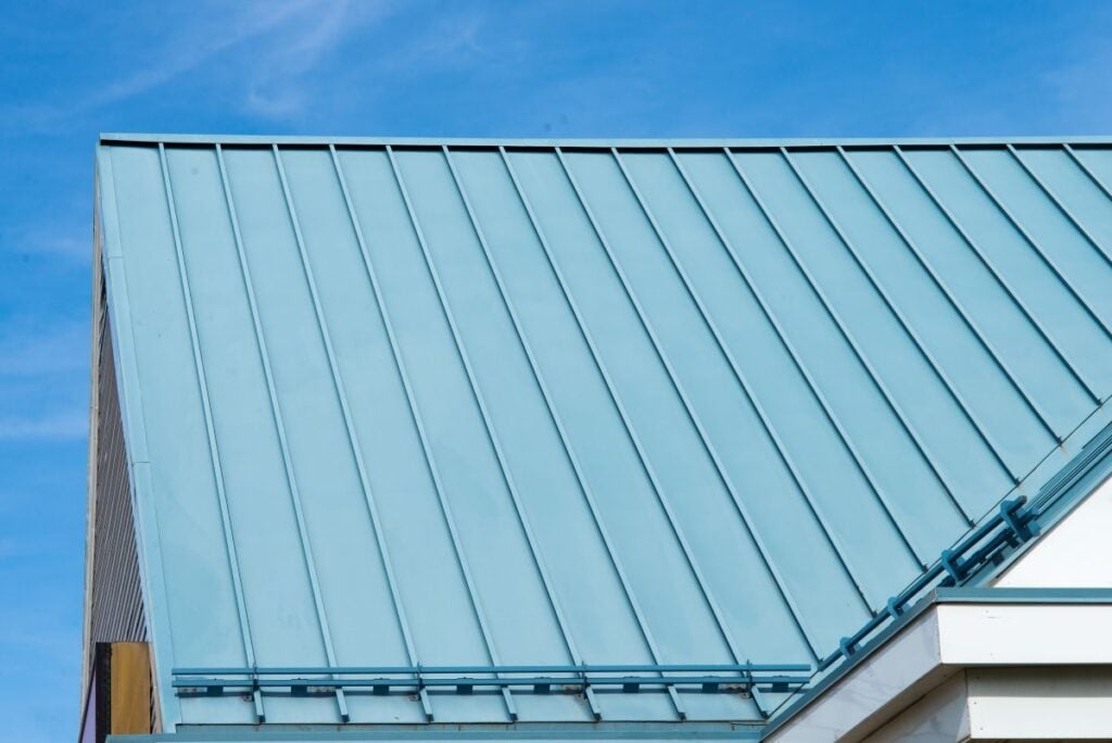 energy efficient roofing green metallic roof white wall blue sky
