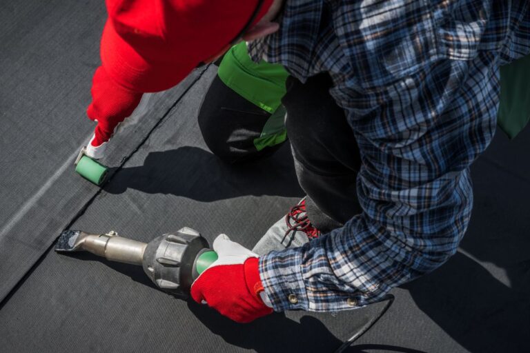 epdm roof worker installing using roller