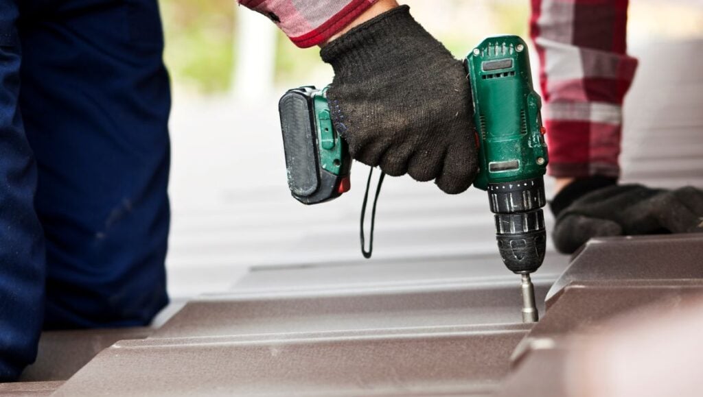 metal roof installation worker using red shirt and dark gloves