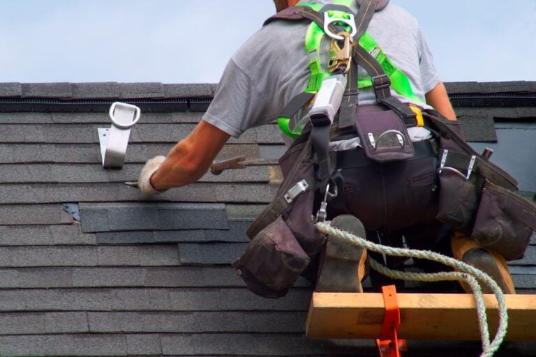 roof warranty worker installing shingles using protection