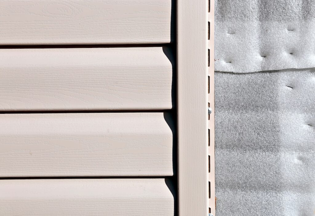 Installation on facade of the house panels beige vinyl siding