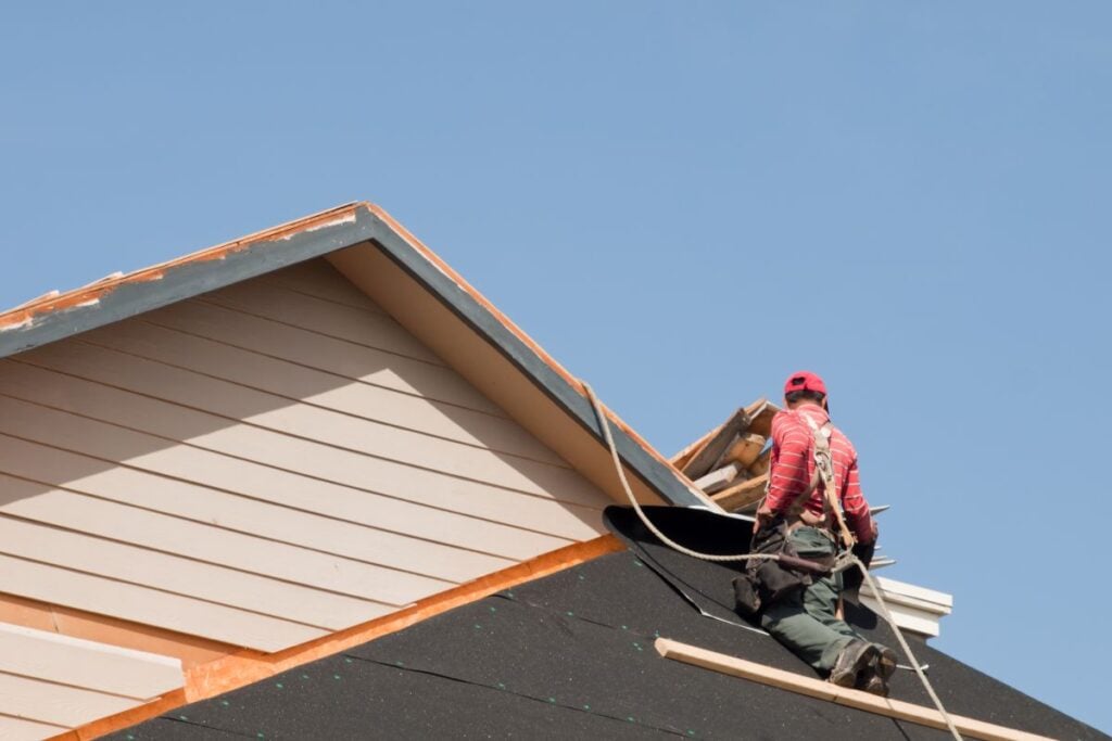roof sealant  worker using safety equipment replacing shingles
