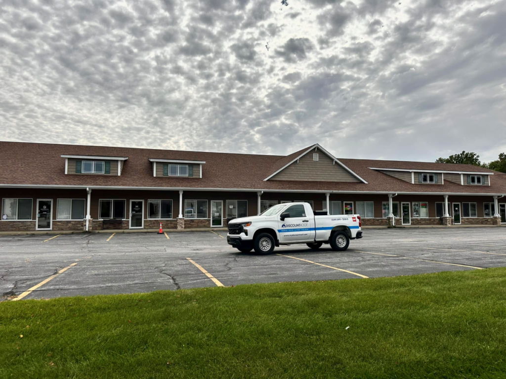 gutter parts Discount roofing branded truck outside of big house