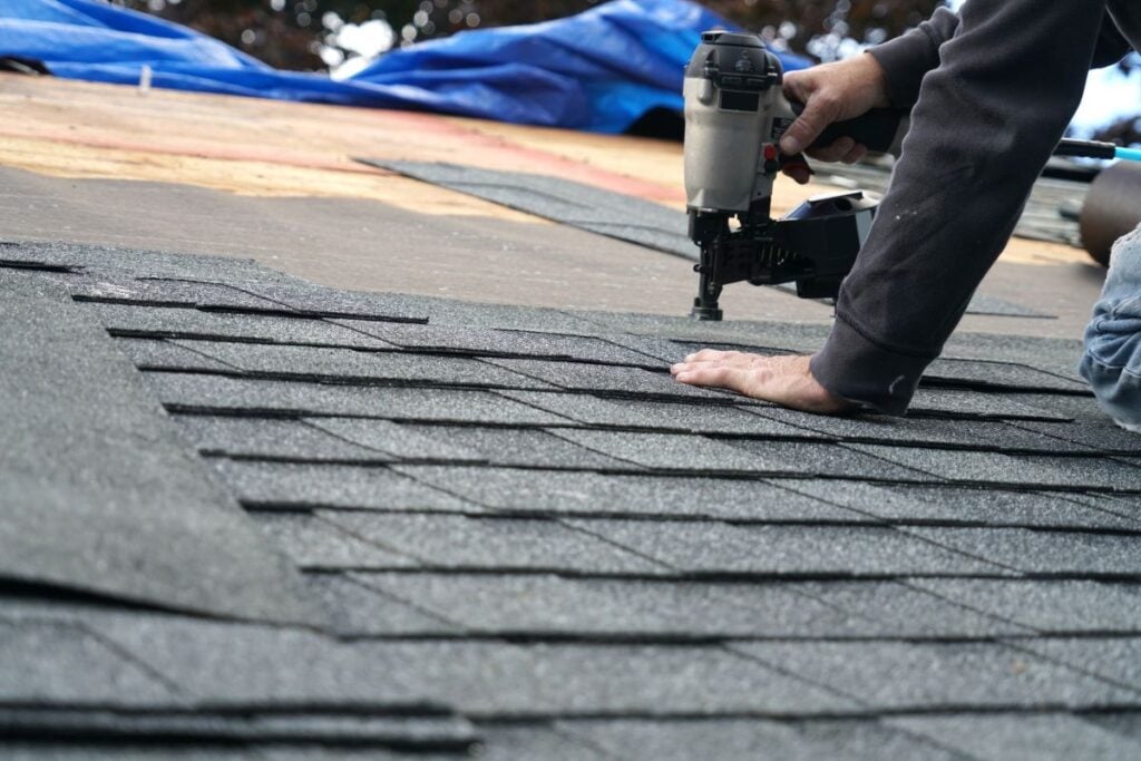roofing tips worker using nail gun to change shingles