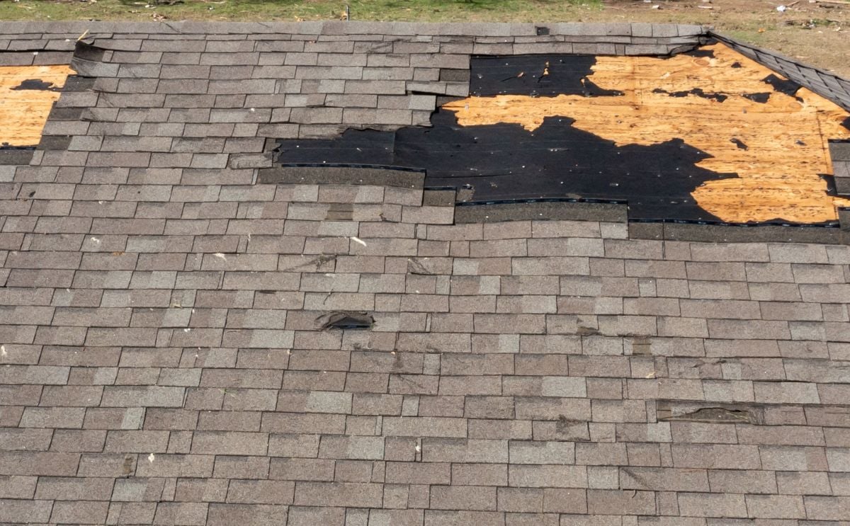 Tornado damage to roof with missing shingles.