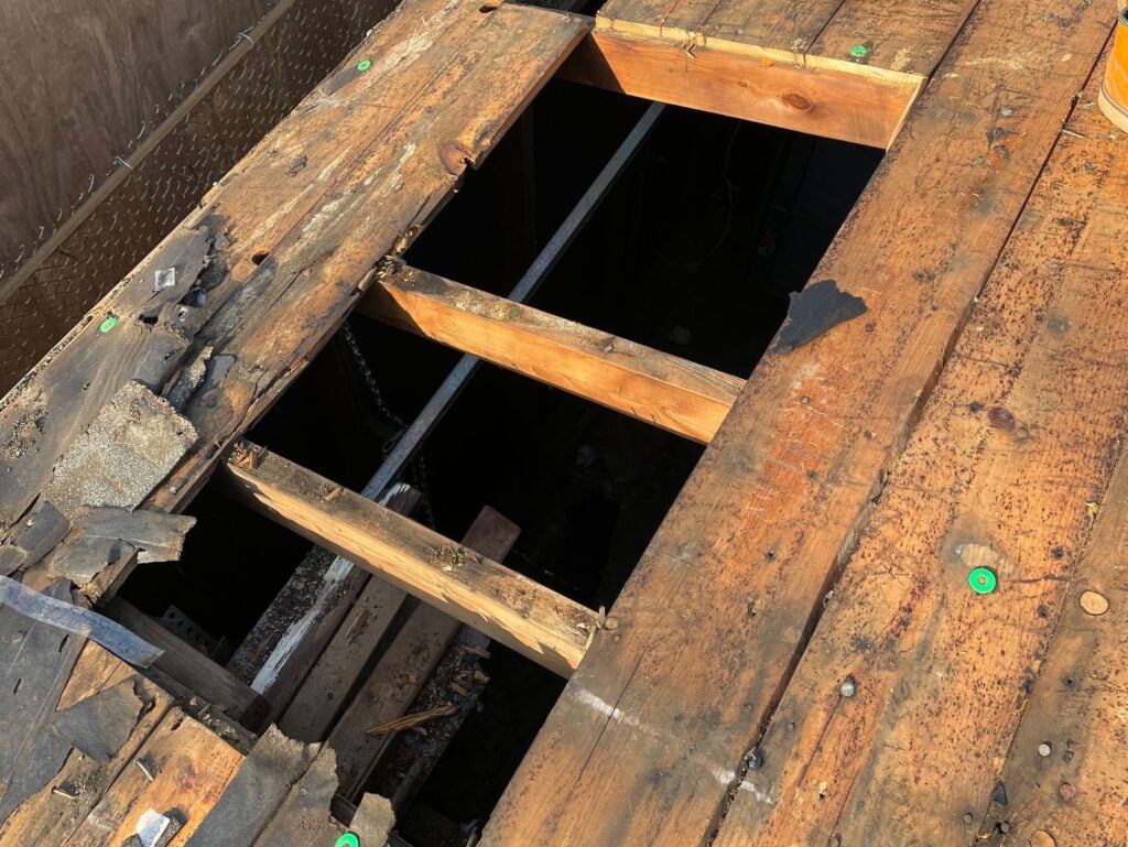 roof decking man standing nex to the hole