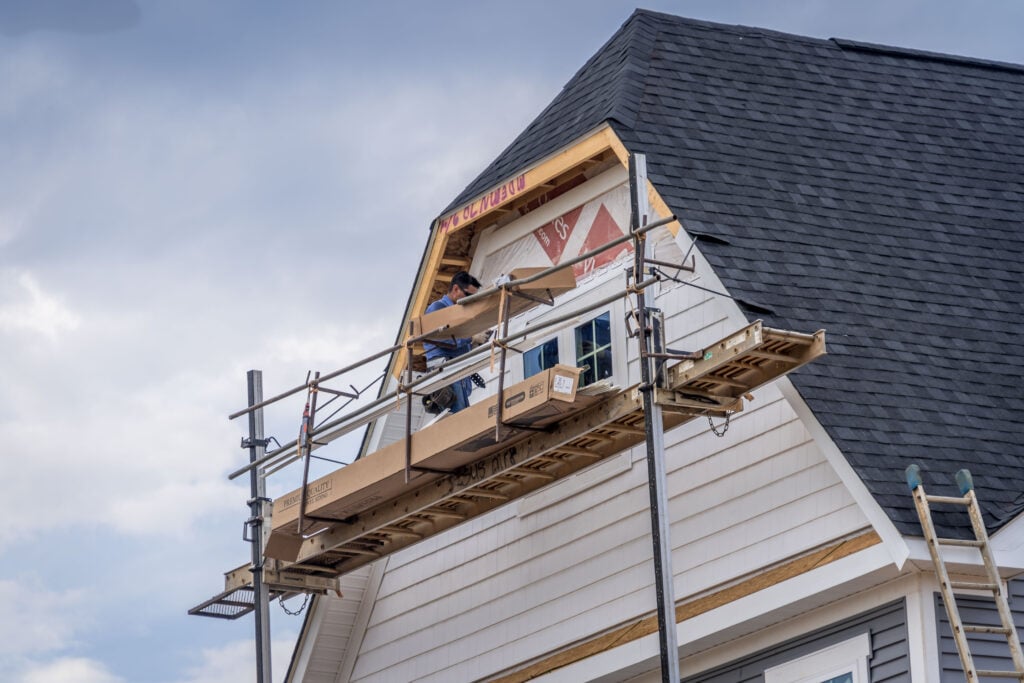 fiber cement siding installation worker installing new siding