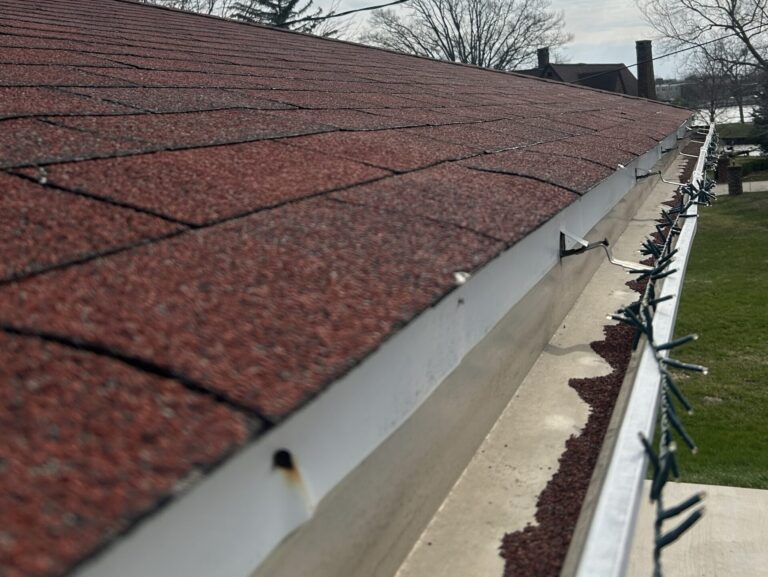 seamless vs sectional gutters brown shingles closeup dirty water system