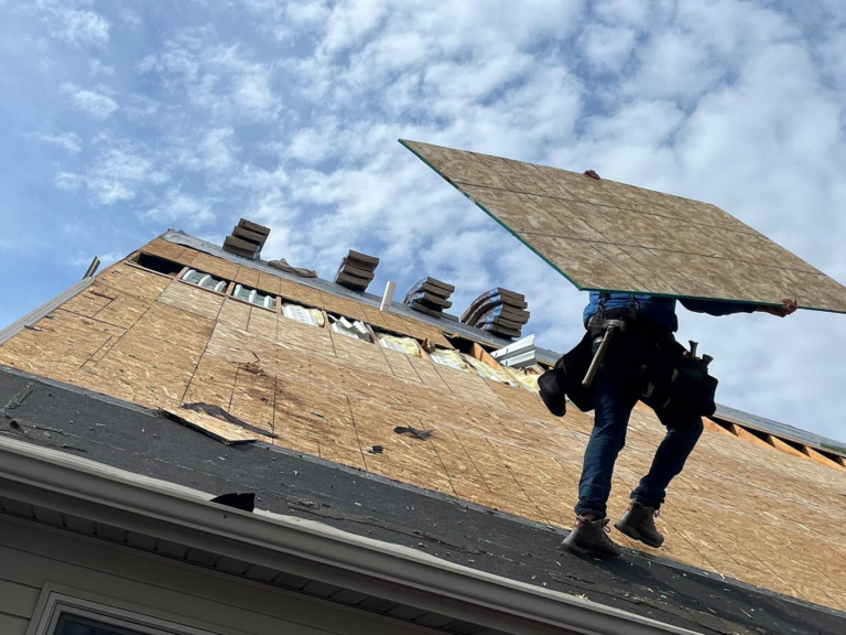 roof decking worker holding wooden plank