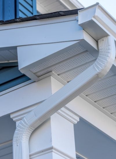 Colonial white gutter guard system, fascia, drip edge, soffit providing ventilation to the attic, with pacific blue vinyl horizontal siding at a luxury American single family home neighborhood USA; gutter maintenance; gutter replacement; gutter cleaning; gutter repair