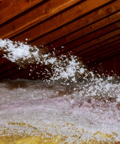 Worker Spraying mineral rock wool of house attic insulation