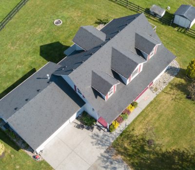 Drone view of single family house Drone view of single family house; roof replacement services; how long does a roof last; types of roofing materials